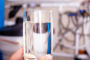 Close up of someone holding a glass of clear drinking water