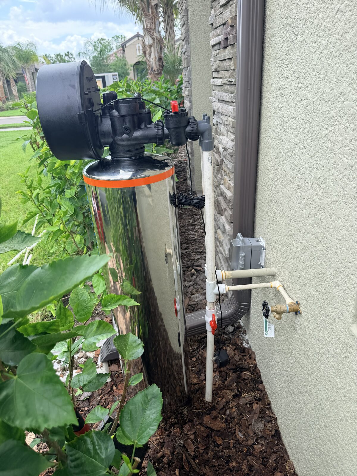 Puronics water softener with a wall-mounted hose bib
