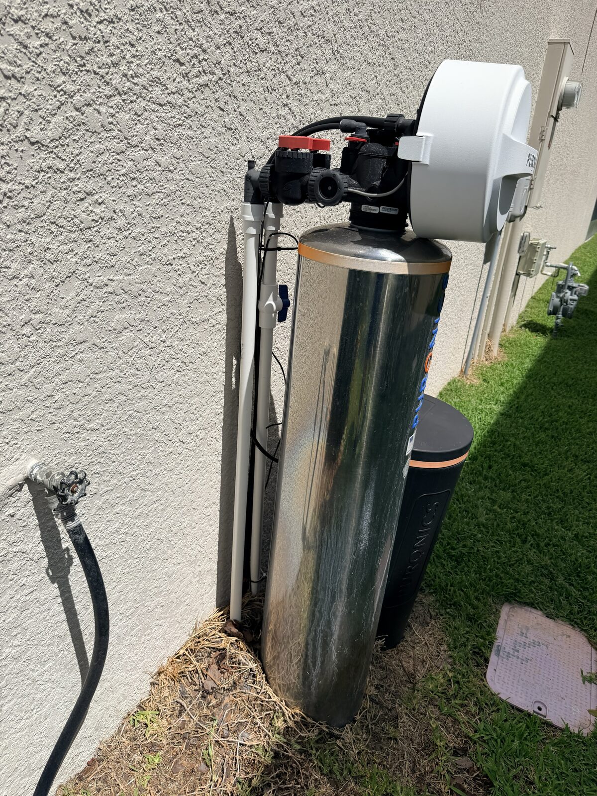 Outdoor Puronics stainless whole-home water softener and brine tank