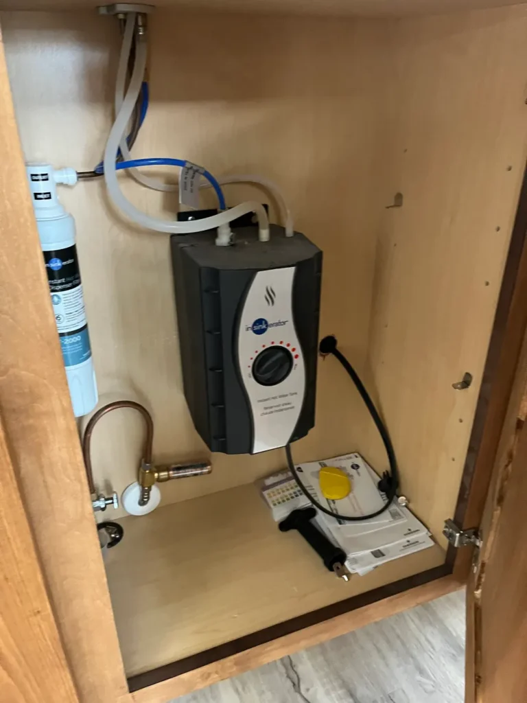 Instant hot water dispenser tank and inline filter mounted inside an under-sink cabinet by Hydrology Water Solutions