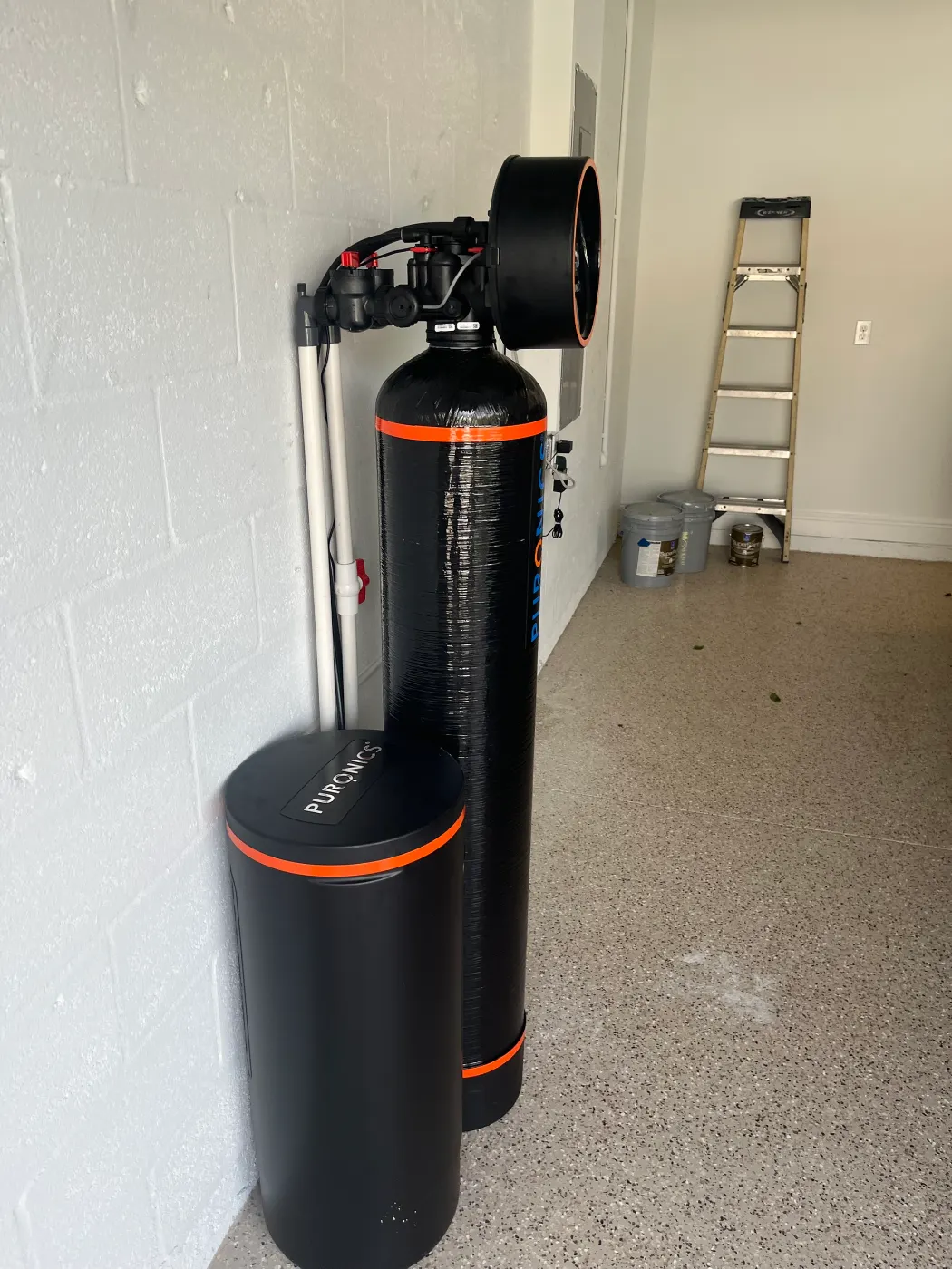 Puronics whole-home system and brine tank installed by Hydrology Water Solutions in a new-construction garage