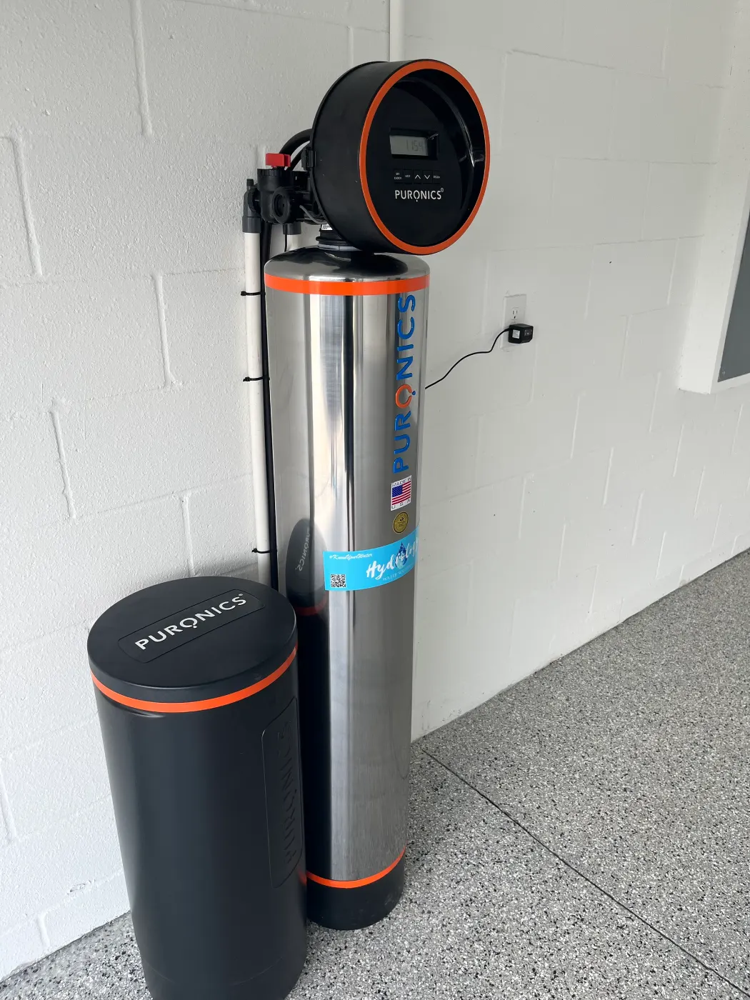 Puronics whole-home system and brine tank installed by Hydrology Water Solutions, carrying the Hydrology service tag