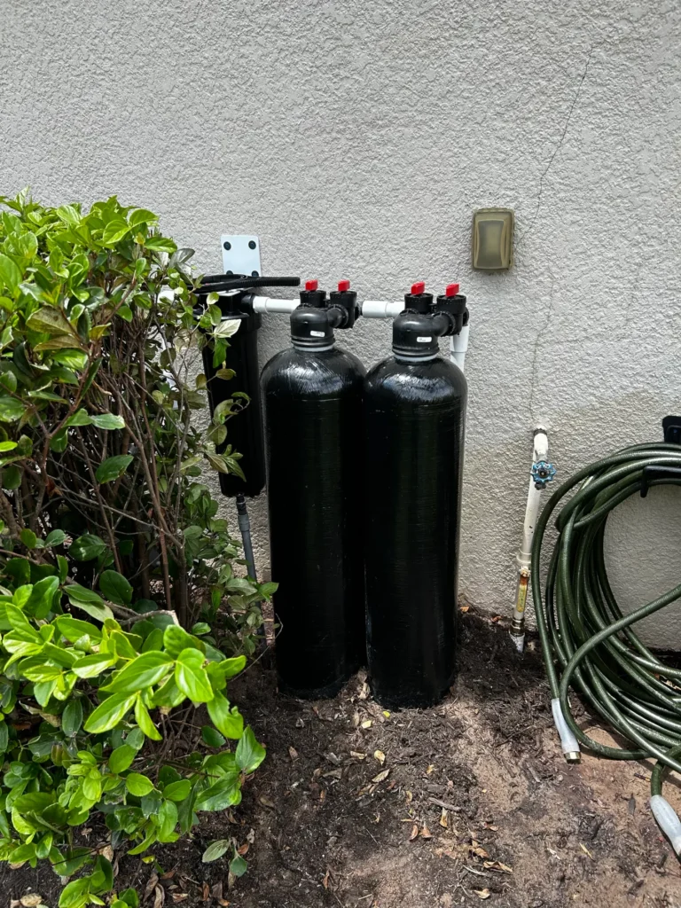 Custom twin-tank whole-home water treatment build with bypass valves installed outside a Suncoast home