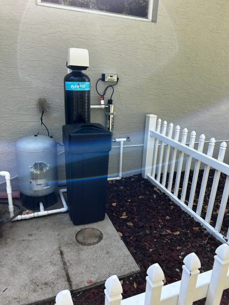 Well water system with Hydrology-branded filter tank, brine tank, UV disinfection unit and pressure tank installed by Hydrology Water Solutions