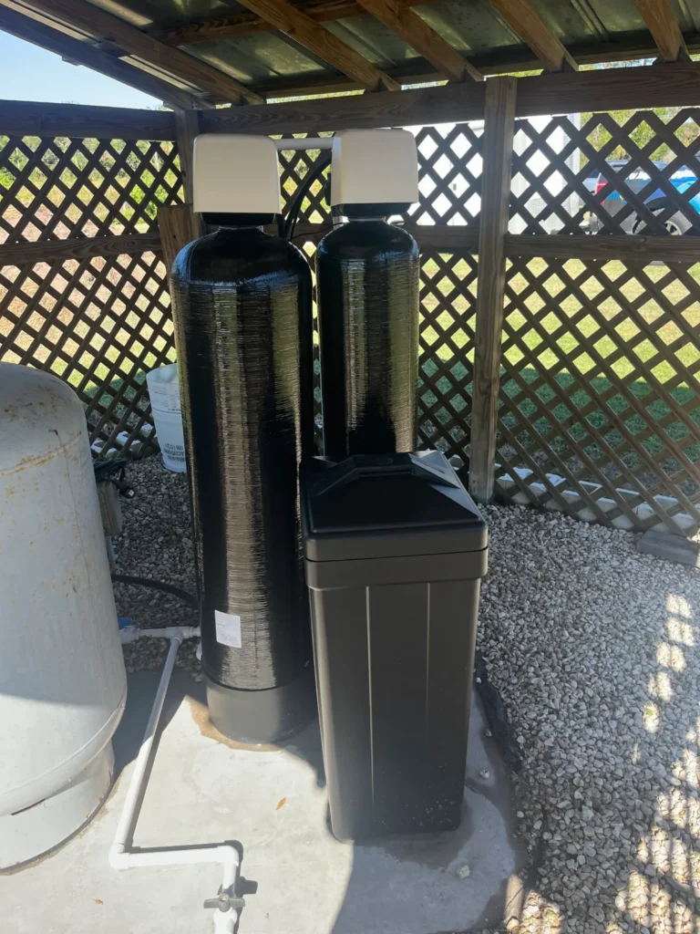 Well water treatment system under a shelter installed by Hydrology Water Solutions in Ruskin, Florida