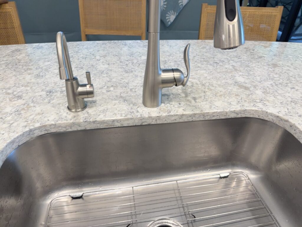 Instant hot water dispenser faucet installed beside a brushed-nickel kitchen faucet