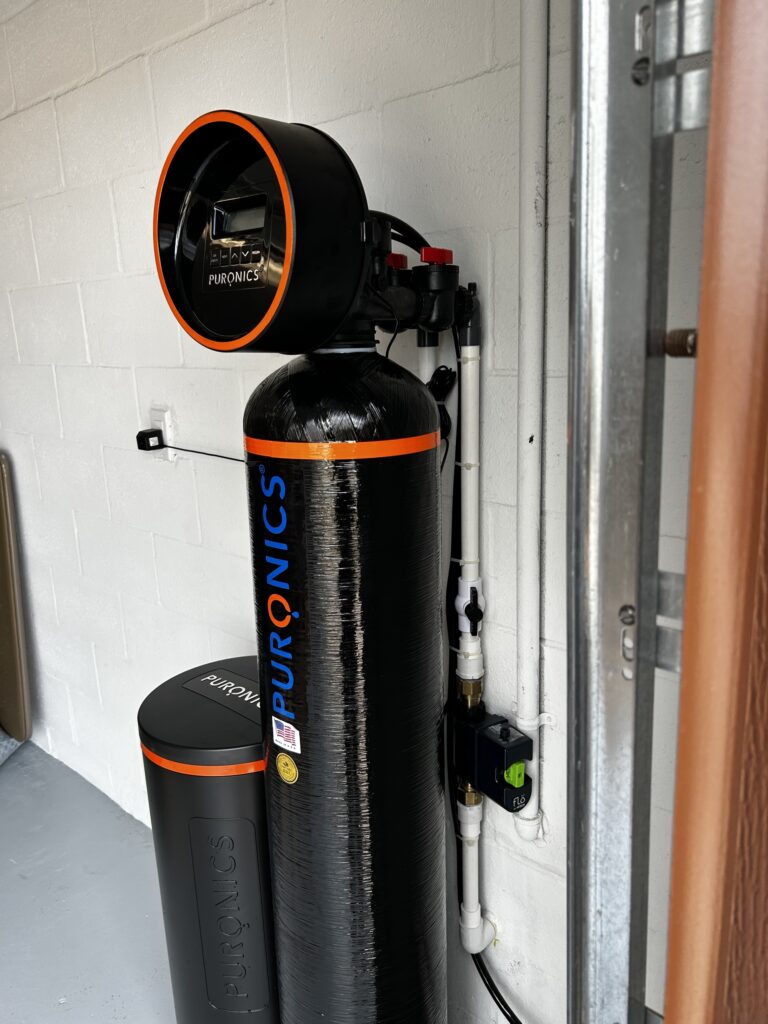 Flo by Moen smart water shutoff installed on the main line beside a Puronics softener
